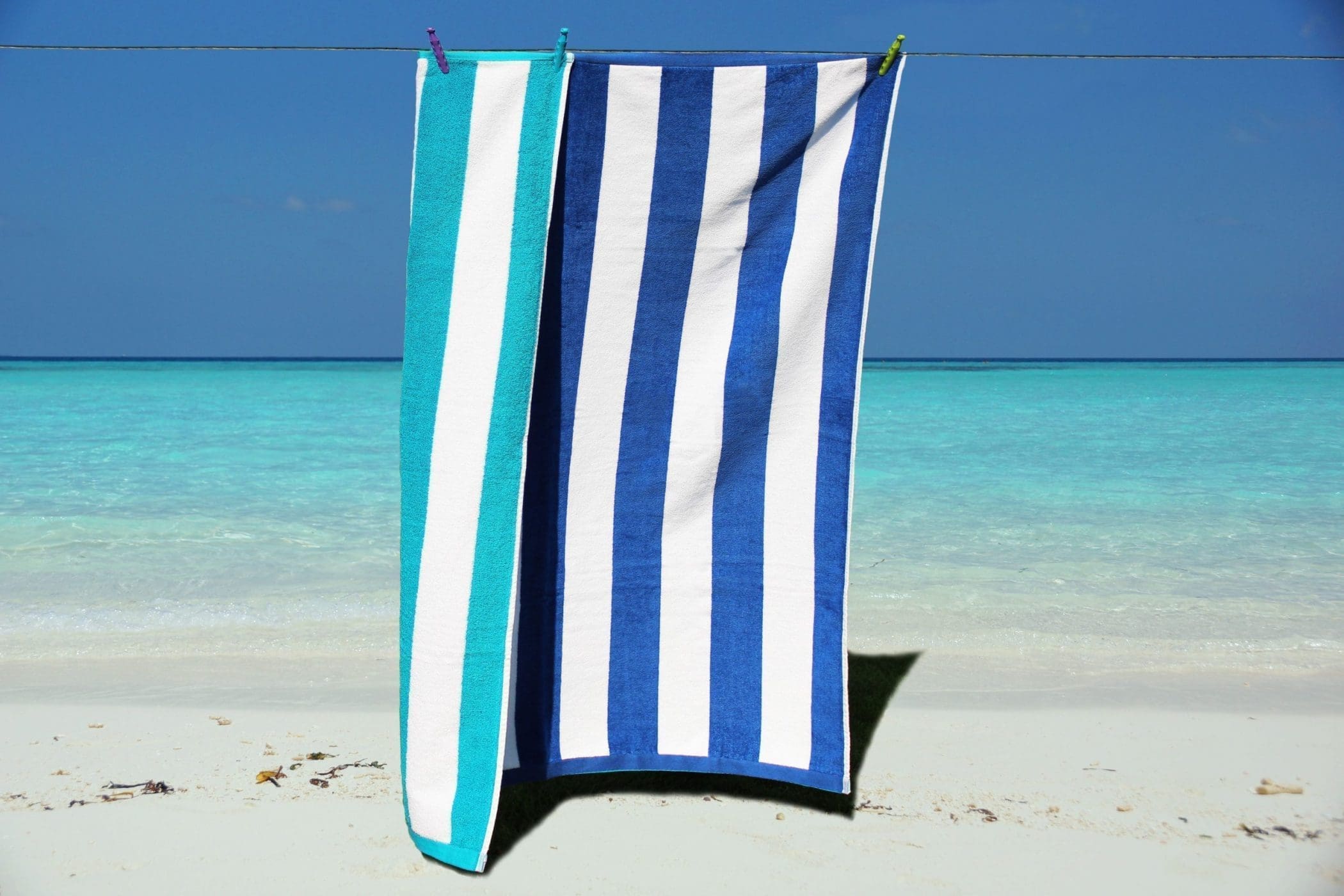 Blue and white striped luxury velour beach towel folded on a sun lounger